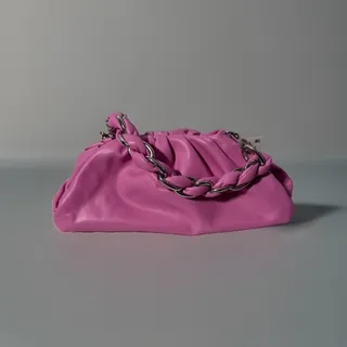 Photo of INC International Concepts pink slouchy pouch bag with silver chain strap.