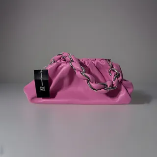 Photo of INC International Concepts pink slouchy pouch bag with silver chain strap.